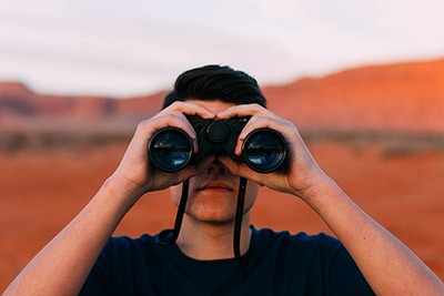 Photographie de face d'un homme portant des jumelles